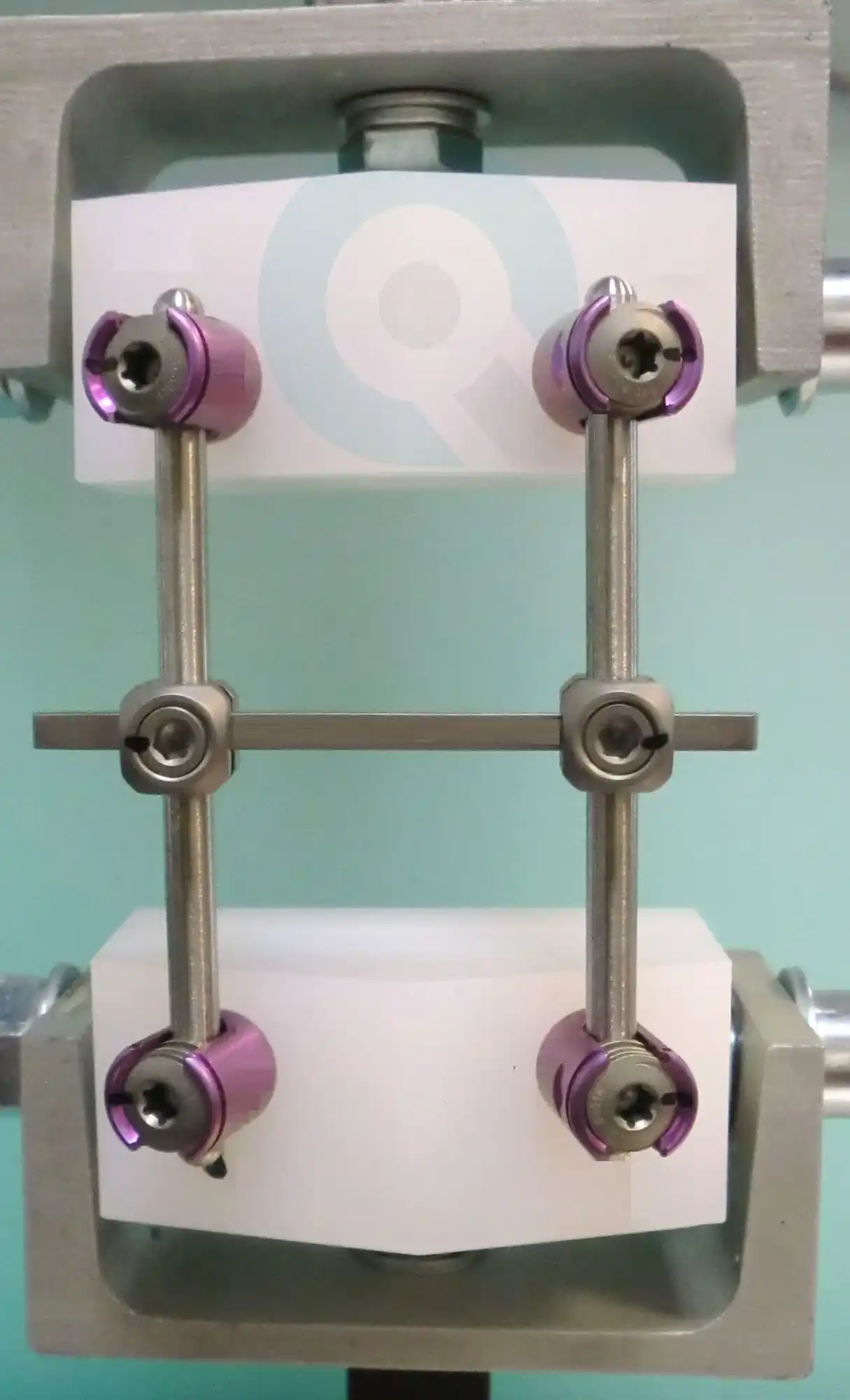 The image shows a test setup for the fatigue testing of spinal implants according to ASTM F1717